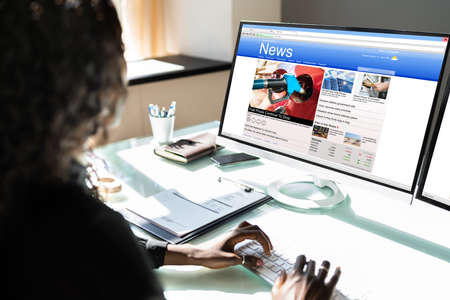 Black Woman Watching News Online On Computerの写真素材