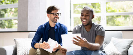 Happy Gay Couple Reading Letter Or Mail