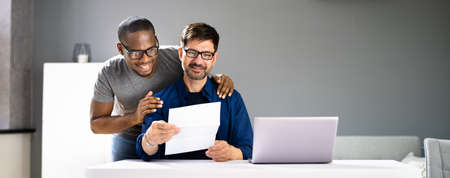 Happy Gay Couple Reading Letter Or Mailの写真素材