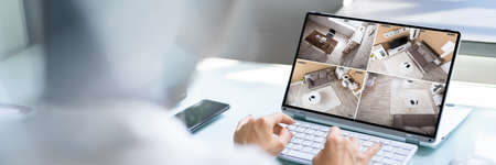 Hand Checking CCTV Camera Footage On Laptop