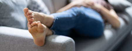 Stinky Feet Resting On Couch. Foot Smell On Sofa