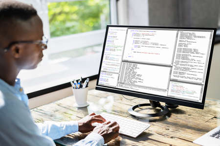 African American Coder Using Computer At Desk. Web Developerの写真素材