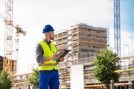 OSHA Inspector At Construction Site. Young Engineer Worker