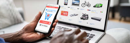 African American Using Online Ecommerce Store On Laptop And Phone