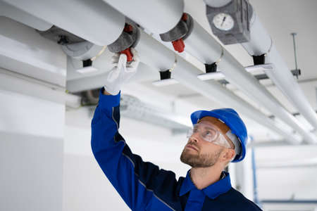 PVC Water Pipe Inspection By Construction Worker