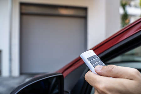 Automatic Wireless Home Garage Door. Hand Using Controller In Car