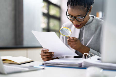 Lawyer Examining Paper Using Magnifier Glass. Tax Fraud Investigationの写真素材