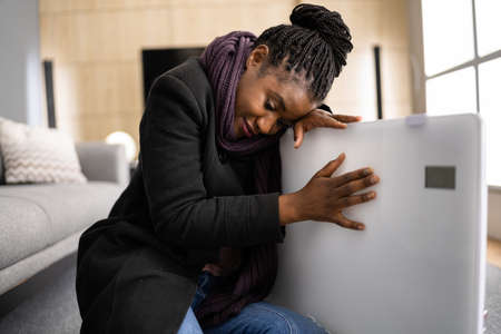 Cold Woman In Jacket Sitting Near Heater At Home