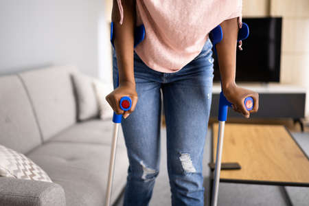 Walking With Crutches. Injured Broken Leg Or Knee