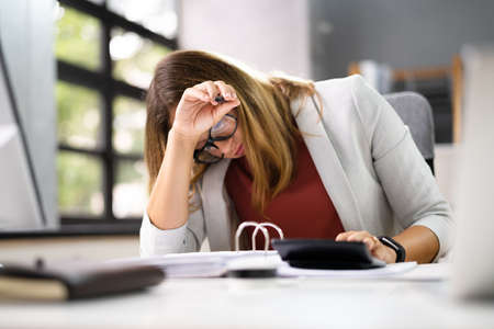 Stressed Accountant Woman With Headache In Officeの写真素材