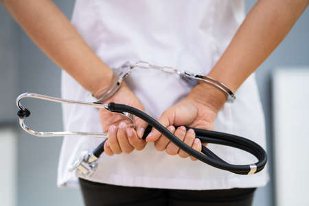 Medical Malpractice And Medicine Fraud. Healthcare Physician In Handcuffs