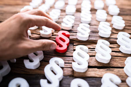 Person's Hand Holding Red Paragraph Sign. Law And Regulationの写真素材