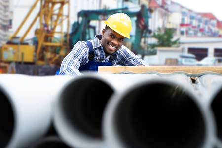 Construction Worker Builder Working At Site. Pipes And Sewageの写真素材
