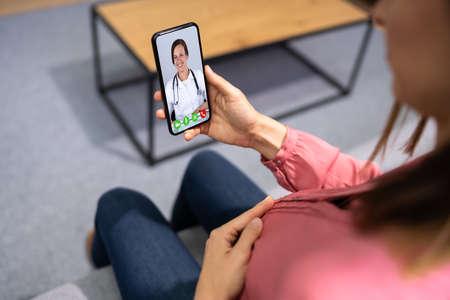 Pregnant Women Doctor Video Call On Phone At Homeの写真素材