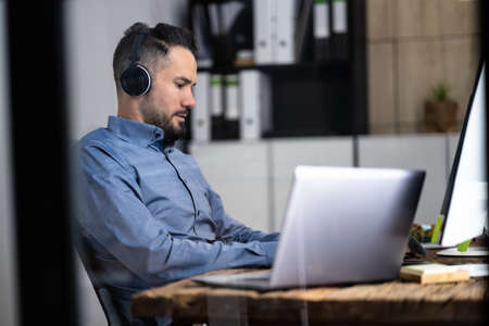 Employee Working On Desktop Computer In Home Office