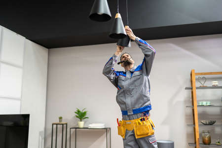 Home Ceiling Light Equipment Maintenance. Professional Electrician Workerの写真素材