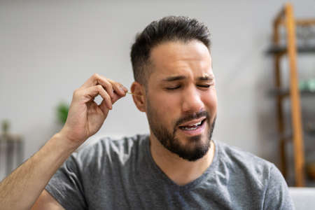Ear Cleaning Health Hygiene. Man Using Cotton Swab
