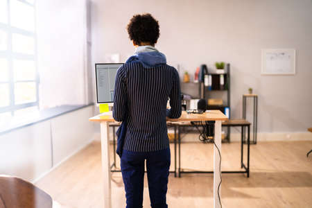 Adjustable Height Desk Stand In Office Using Computerの写真素材