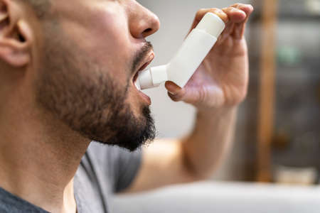 Man With Asthma Using An Asthma Inhaler For Preventing Attacks