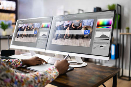 Graphic Designer Artist Working On Multiple Computer Screensの写真素材