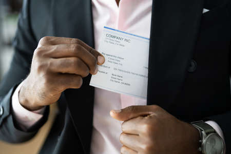 Holding Paycheck Or Payroll Check Or Insurance Cheque In Handの写真素材