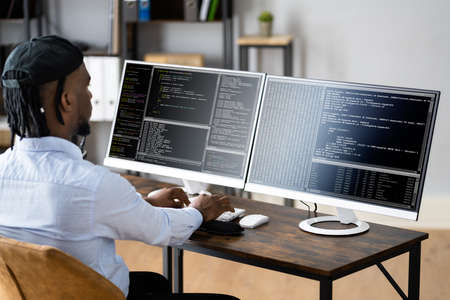 African American Coder Using Computer At Desk. Web Developer