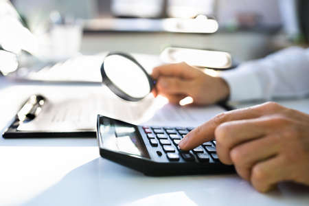 Business Auditor Using Magnifying Glass For Paperwork Fraud Investigationの写真素材