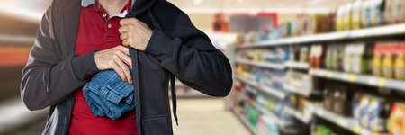 Retail Shoplifting. Man Stealing Jeans. Theft At Shopの写真素材