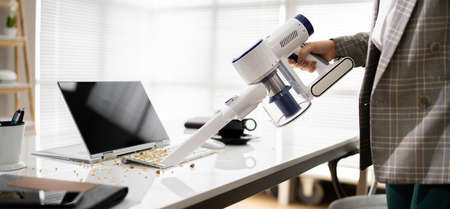 Cleaning Office Desk Using Cordless Vacuum Cleaner