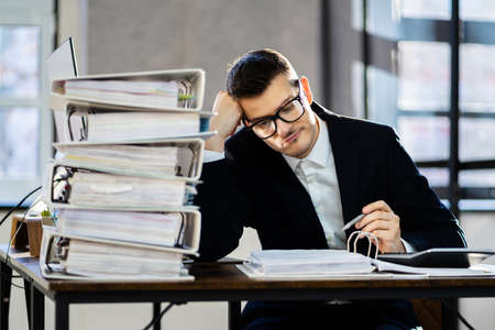 Bored Workaholic Businessman At Office Desk With Stress