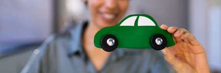 African Woman's Hand Holding Green Electric Carの写真素材