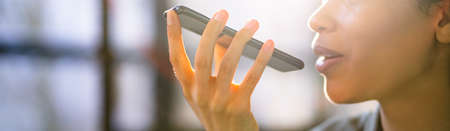Young Woman Using Voice Recognition Function On Mobile Phoneの写真素材