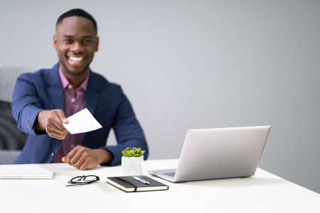 African Business Man Giving Paycheck Or Payroll Chequeの写真素材
