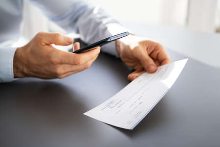 Remote Check Deposit Taking Photo With Mobile Phoneの写真素材