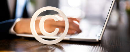 Copyright Sign Near Man's Hand Working On Laptop