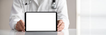 Close-up Of Male Doctor's Hand Holding Digital Tablet With Blank White Screen On White Deskの写真素材
