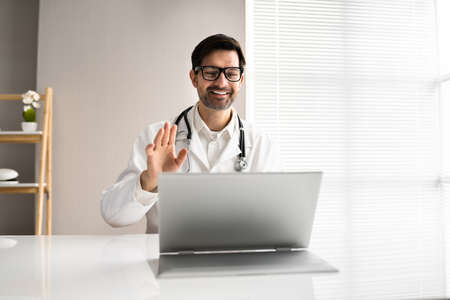 Doctor Having Video Conference On Laptop With Colleaguesの写真素材