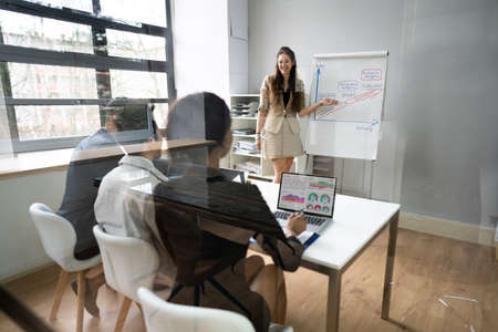 Woman Giving Business Presentation In Group Meeting