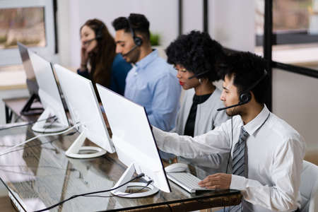 Positive Customer Services Agent With Headset Working In A Call Centerの写真素材