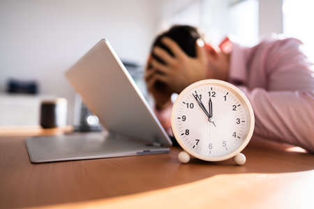 Unhappy Stressed Man In Office With Deadline Pressureの写真素材