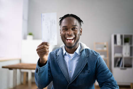 Holding Paycheck Or Payroll Check Or Insurance Cheque In Handの写真素材