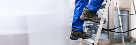 Man Climbing Step Ladder In Safety Shoesの写真素材