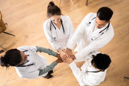 Medical Team Stacking Hands Against In Hospital