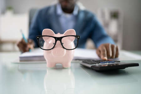 Financial Advisor With Piggybank. Money Saving Calculationの写真素材