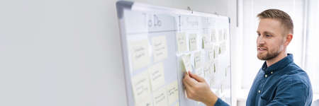 Man Writing Kanban Plan On Wall Board
