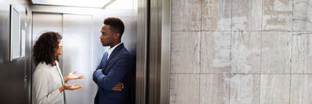 Young African Businesspeople Having Conversation In Elevator