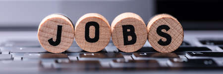 Close-up Of Jobs Text On Wooden Blocks Over Keyboard In Office