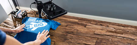 Man Printing On T Shirt In Workshop