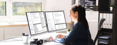 Coder Engineer Using Multiple Monitors At Deskの写真素材