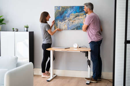 Happy Couple Hanging Painting. Wall Decoration At Home